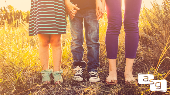 Siblings united, holding hands in a sunny field. Blog discussing the importance of thorough sales training evaluation.