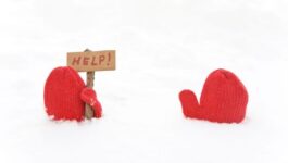 Two red mittens stick out of the snow, with one holding a small wooden stick that displays a sign reading "HELP!" The image humorously illustrates the struggle and misalignment in sales conversations, where buyers often feel lost or unsupported. This emphasizes the blog's focus on addressing buyer challenges and guiding them effectively to prevent stalled deals and churn.